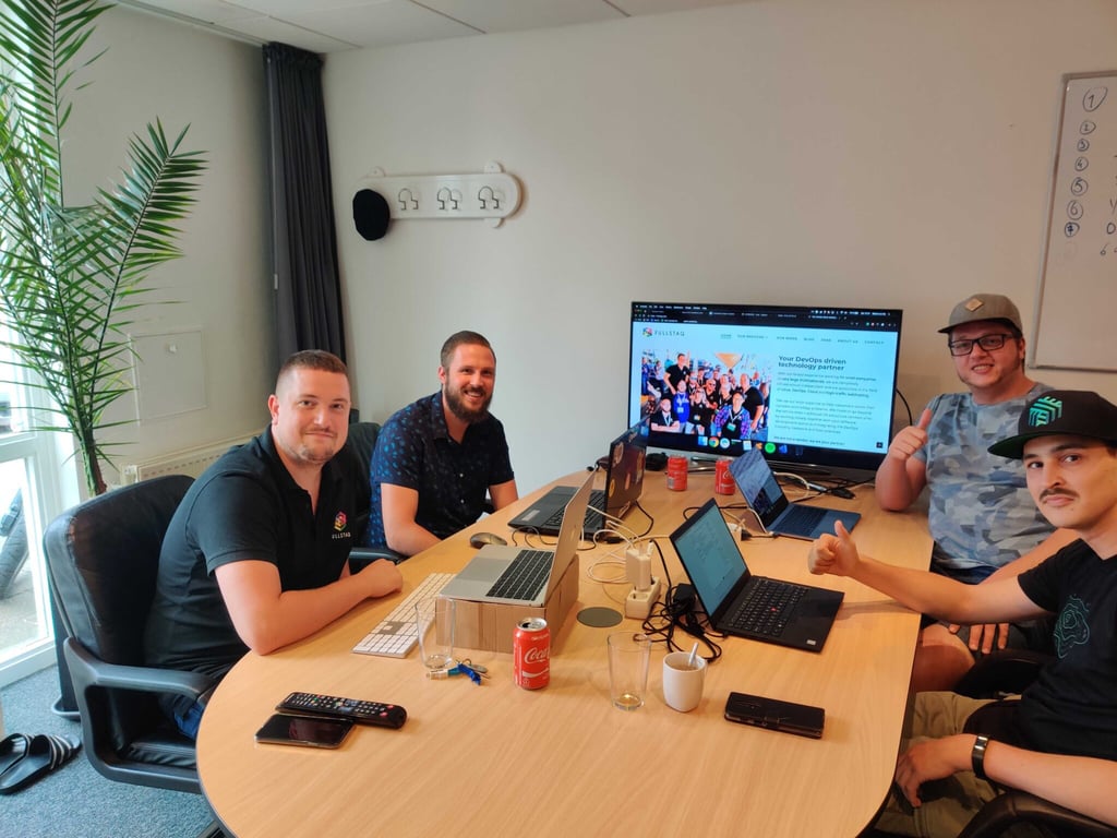 Hackathon team: engineers sharing a desk and smiling into the camera