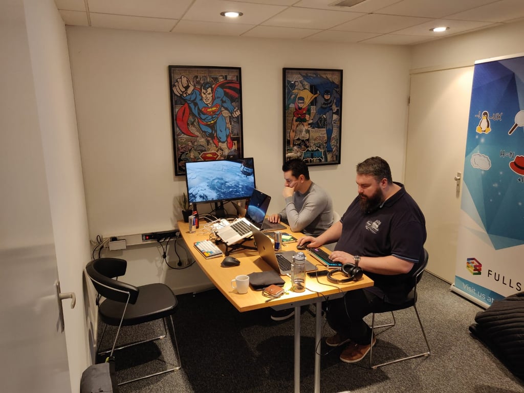 Hackathon team serverless: two engineers, sharing a desk, are drawn into their computer